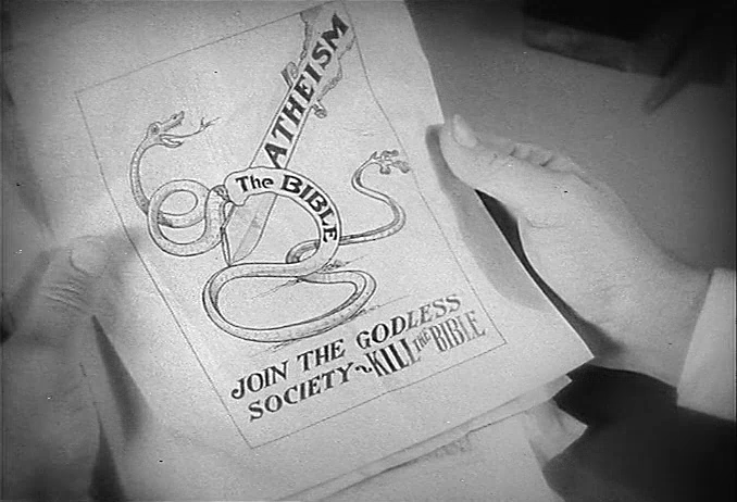 Black and white image of hands hold a pamphlet with a graphic of a snake labeled "The BIBLE" being cut in half by a sword labelled "ATHEISM." Text below the image reads "Join the Godless Society- Kill the Bible."